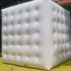 Cube gonflable blanc dont les faces sont retenues par des capitons internes