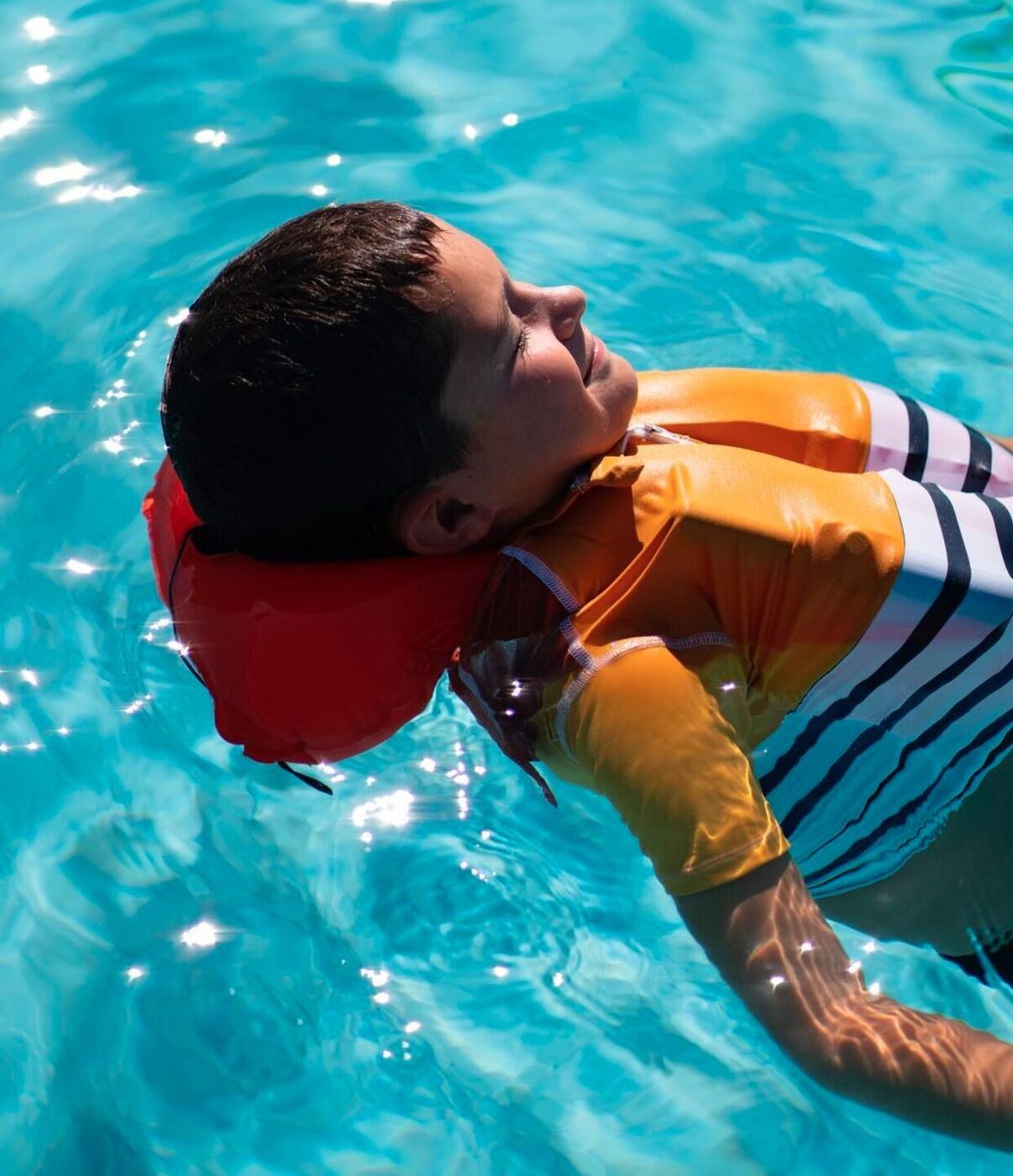 Enfant flottant dans une piscine, gilet Floatee gonflé